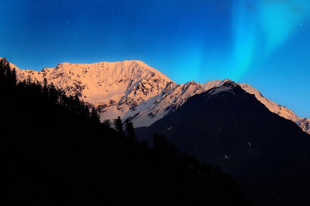 Фото Широкий вид на заснеженные горы на фоне голубого неба ночью