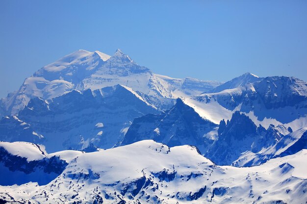 写真 青い空を背景に雪に覆われた山の景色