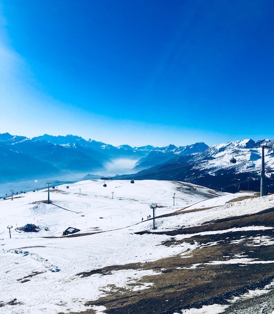 写真 青い空を背景に雪に覆われた山の景色