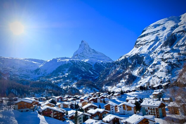 写真 青い空を背景に雪に覆われた山の景色