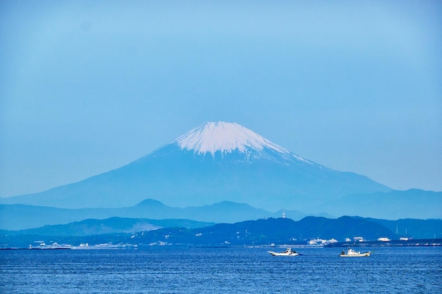 写真 晴れた空を背景に雪に覆われた山の景色