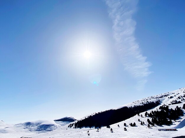 写真 晴れた日に空を背景に雪に覆われた山の景色