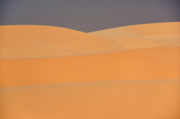 Photo scenic view of orange sky over desert