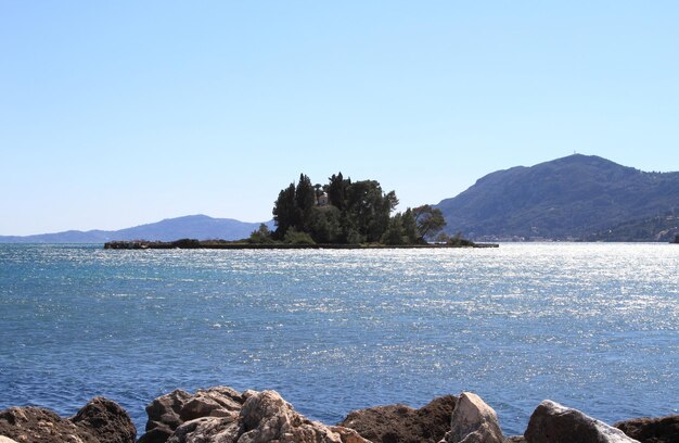 Photo scenic view of pontikonisi island behind the rocks