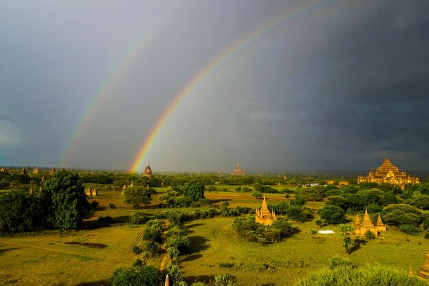 Scenic view of rainbow over field against sky