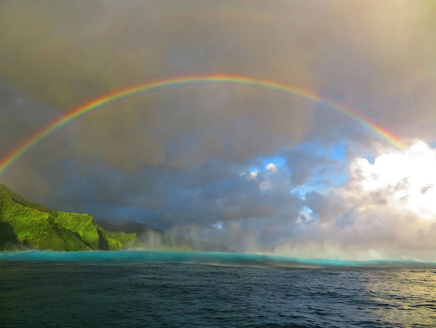 Photo scenic view of rainbow over sea against sky