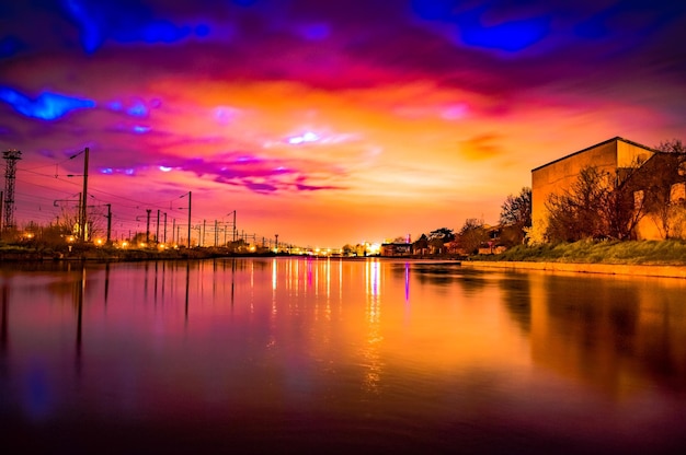 Photo scenic view of river against dramatic sky during sunset