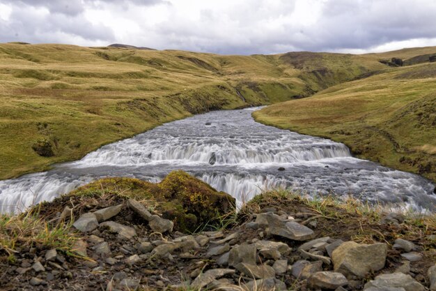 Scenic view of river amidst landscape against cloudy sky