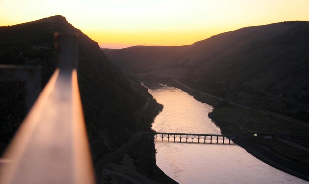 Scenic view of river amidst mountains against sky during sunset