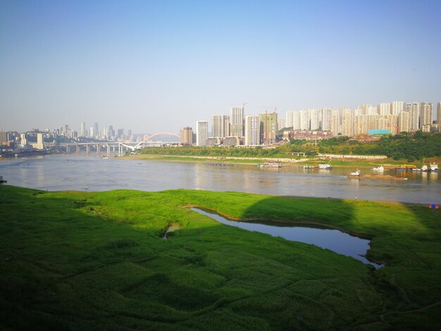 Scenic view of river and buildings against clear sky