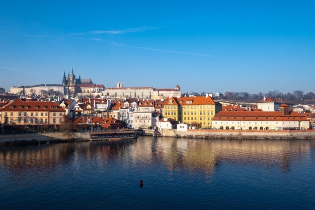 Scenic view of river by buildings against blue sky