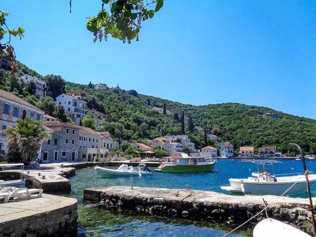 Scenic view of river by buildings against clear blue sky