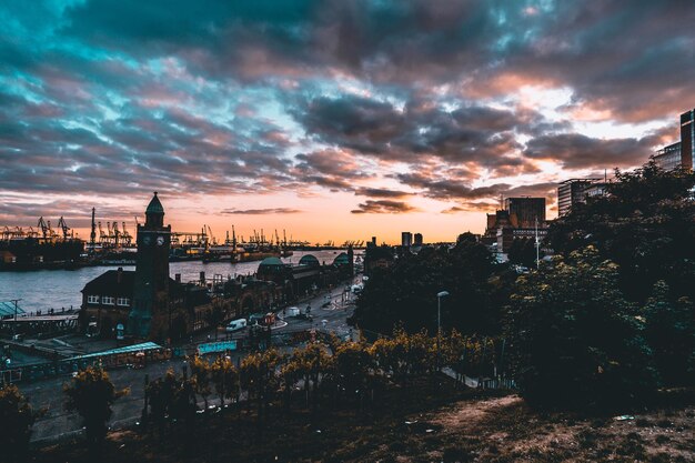 Scenic view of river by buildings against sky at sunset