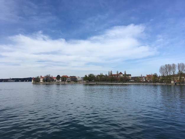 Scenic view of river by buildings against sky