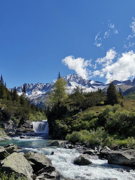 Scenic view of river by mountains against sky