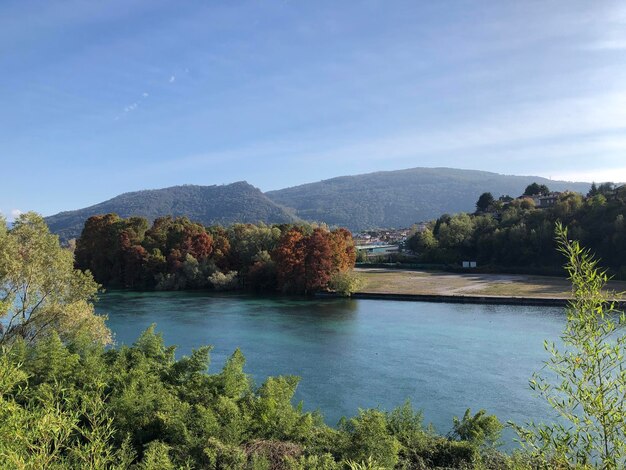 Scenic view of river by mountains against sky