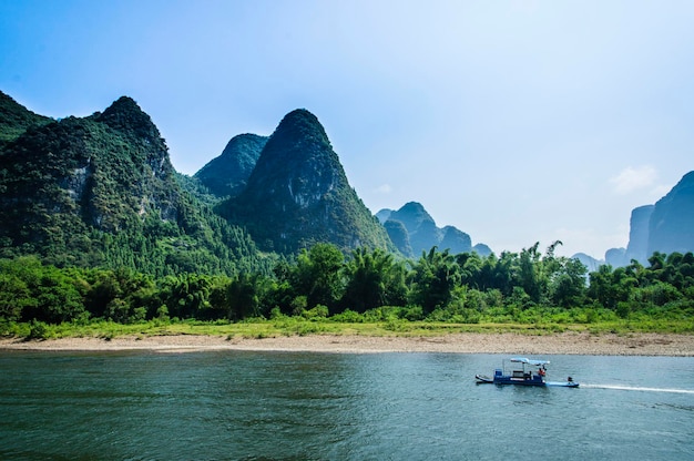 Scenic view of river by mountains against sky