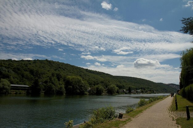 Scenic view of river by tree mountain against sky