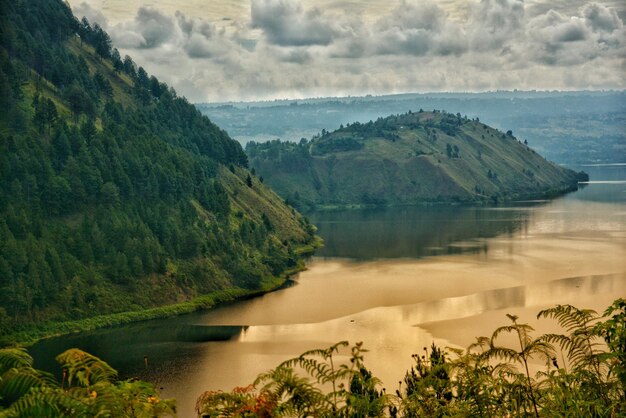 Scenic view of river and mountains against sky