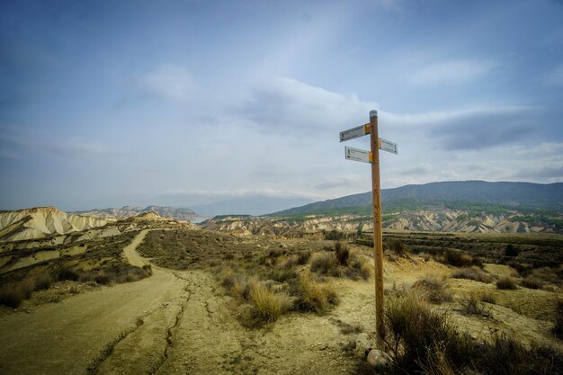 Photo scenic view of road amidst field against sky