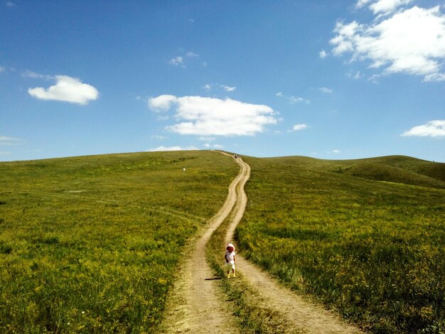 Photo scenic view of road amidst field against sky