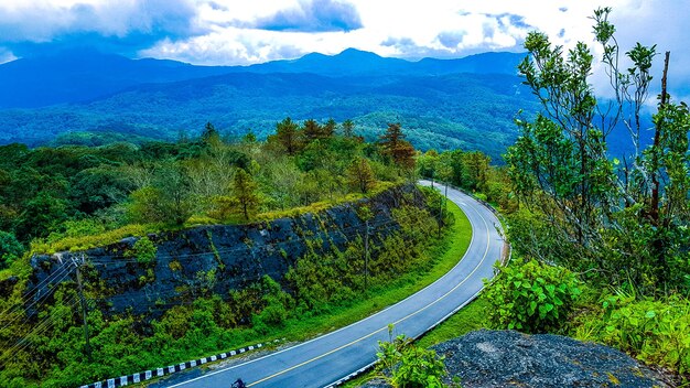 Scenic view of road by mountains against sky