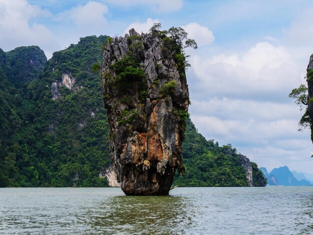 Photo scenic view of rock formation by sea against sky