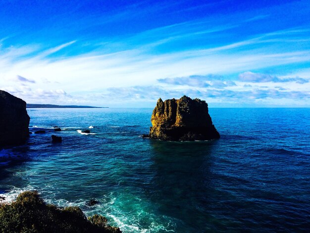 Scenic view of rock formation in sea against sky