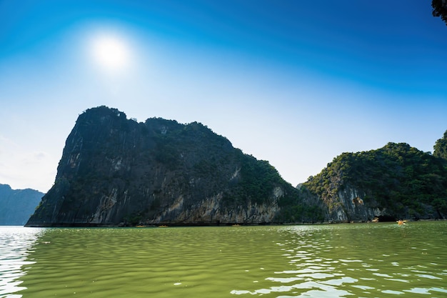 Scenic view of rock island in HaLong Bay Vietnam Southeast Asia UNESCO World Heritage Site Mountain islands at Ha Long Bay Beautiful landscape Popular asian landmark famous destination of Vietnam