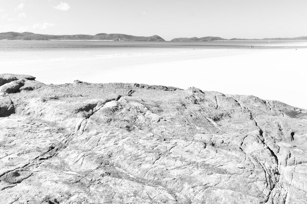 Photo scenic view of rocks on beach against sky