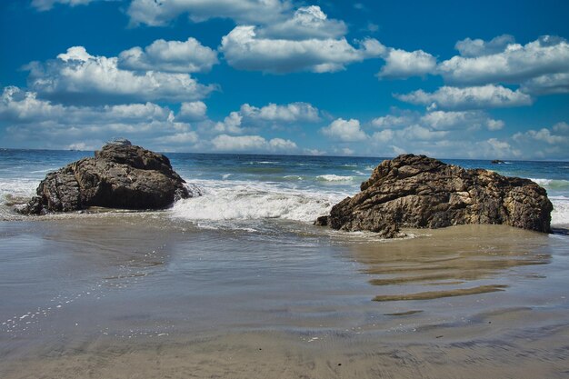 Scenic view of rocks on beach against sky