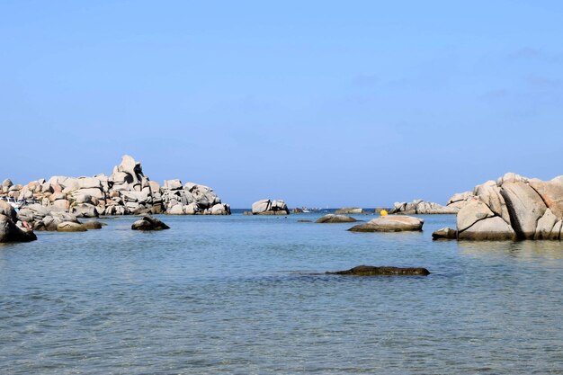 Scenic view of rocks in sea against clear sky