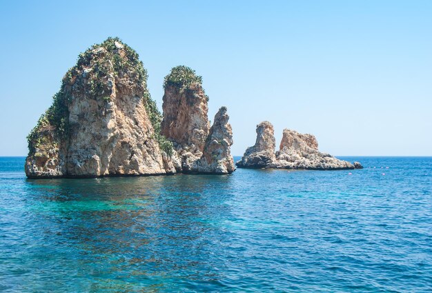 Scenic view of rocks in sea against clear sky