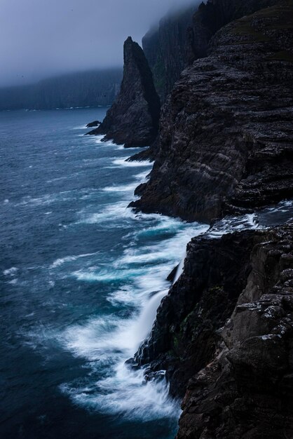 Photo scenic view of rocks in sea against sky