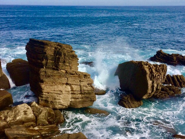 Scenic view of rocks in sea against sky