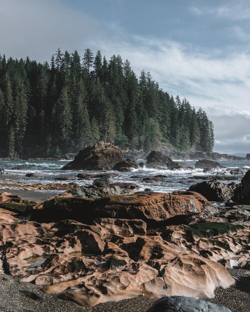 Photo scenic view of rocks in sea against sky