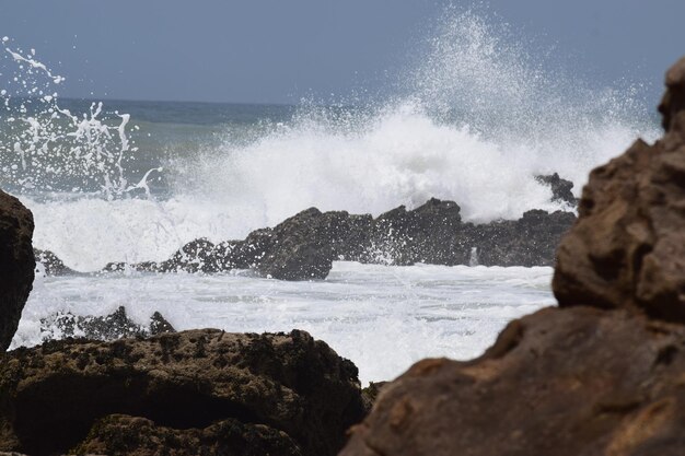 Scenic view of rocks in sea against sky