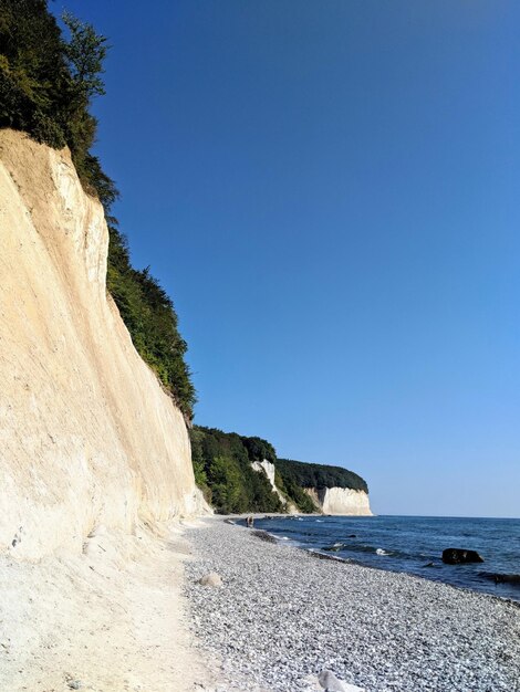 Foto vista panoramica della spiaggia rocciosa contro un cielo blu limpido