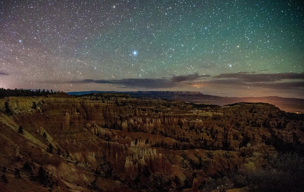 夜の星空の背景にある岩石の山の景色