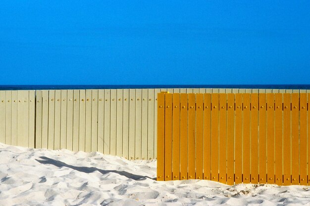 Foto vista panoramica della spiaggia sabbiosa con recinzioni di legno contro un cielo blu limpido