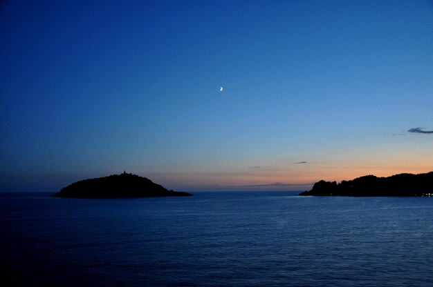 Scenic view of sea against blue sky at sunset