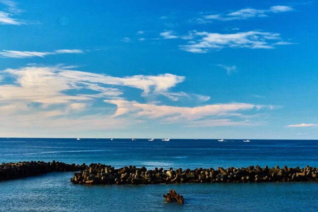 Scenic view of sea against blue sky with clouds