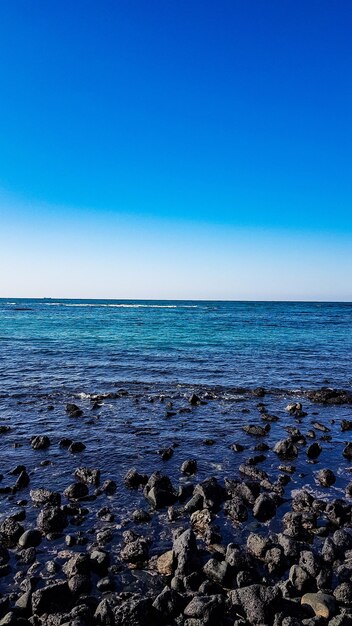 Scenic view of sea against clear blue sky