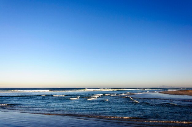 Scenic view of sea against clear blue sky