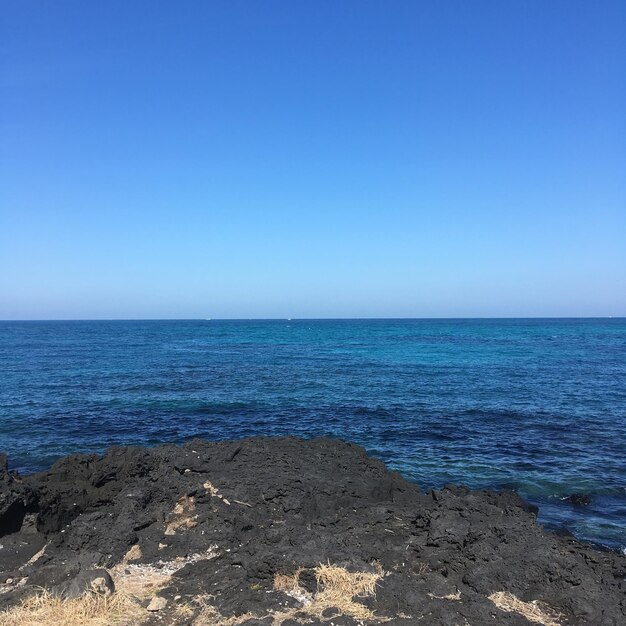 Scenic view of sea against clear blue sky