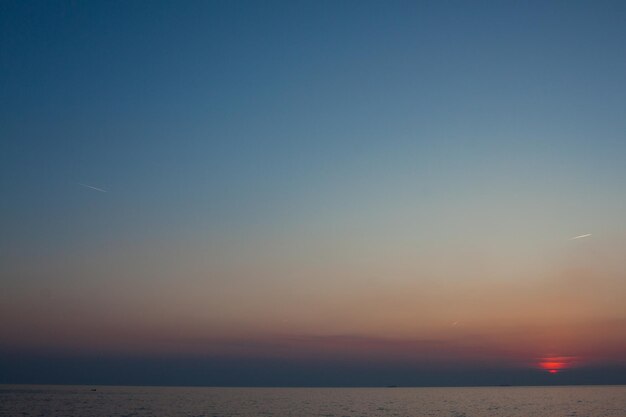 Photo scenic view of sea against clear sky during sunset