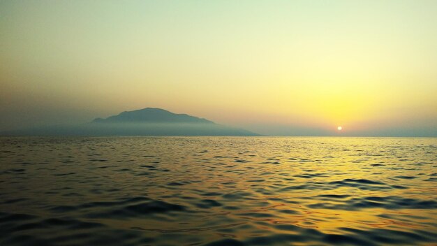 Photo scenic view of sea against clear sky during sunset