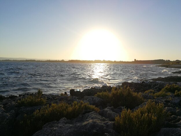 Scenic view of sea against clear sky during sunset