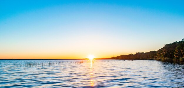 Scenic view of sea against clear sky during sunset