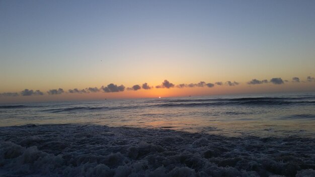 Photo scenic view of sea against clear sky during sunset